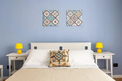 a bedroom with a white bed with two tables and two windows at Agata & Rosalia 2 Suite Indipendenti e Comunicanti con Balcone & AC in Palermo