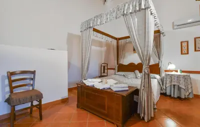 a bedroom with a canopy bed and a chair at Stunning Home In Trappeto With Wifi in Trappeto