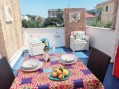 a table with a bottle of wine and fruit on a balcony at Villa Mondello Jacuzzi Room e Terraces Room in Mondello