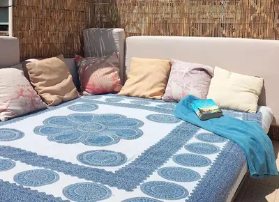 a couch with pillows and a blanket on it at Villa Mondello Jacuzzi Room e Terraces Room in Mondello