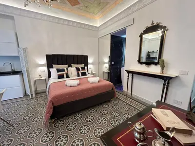a bedroom with a large bed and a mirror at Maqueda view in Palermo