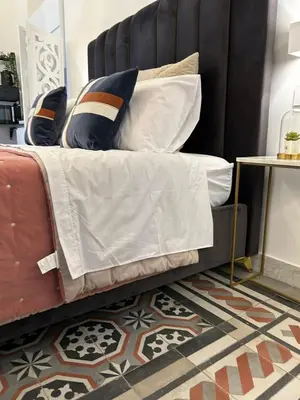 a bed with a black headboard and pillows on it at Maqueda view in Palermo
