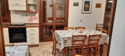 a kitchen with a table with chairs and a table and a table at Casa Lisa in San Vito lo Capo