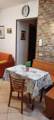a table in a room with a clock on the wall at Casa Lisa in San Vito lo Capo