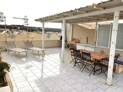 a patio with a table and chairs on a roof at Casa Lisa in San Vito lo Capo