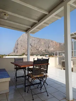 a patio with a table and chairs and a mountain at Casa Lisa in San Vito lo Capo