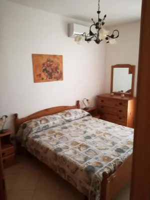 a bedroom with a bed and a dresser and a mirror at Casa Lisa in San Vito lo Capo