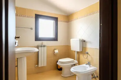 a bathroom with a toilet and a sink at Villa Panorama in Trappeto