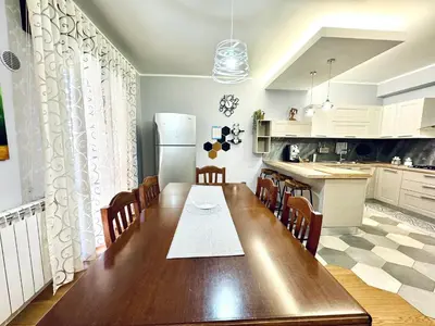 a kitchen with a wooden table and a refrigerator at Ventu di Sciroccu in Cinisi