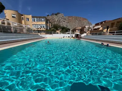 a large swimming pool with blue water at Ashur 163 - Mondello in Palermo