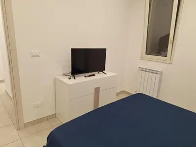 a bedroom with a tv on a white cabinet at Villini AltaVista in Altavilla Milicia