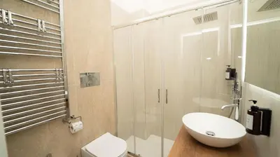 a bathroom with a toilet and a glass shower at Manere Suites in Palermo