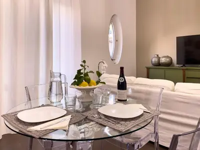 a glass table with two plates and a bottle of wine at Flat44 in Palermo