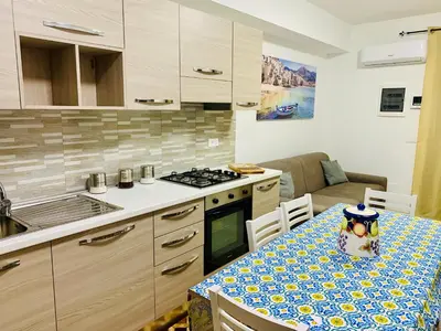 a kitchen with a table and a stove top oven at Campofelice Happy Casa in Campofelice di Roccella