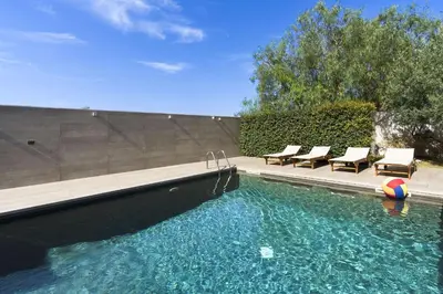 a swimming pool with chairs and a ball in the water at Villa Bizzarria in Castellammare del Golfo
