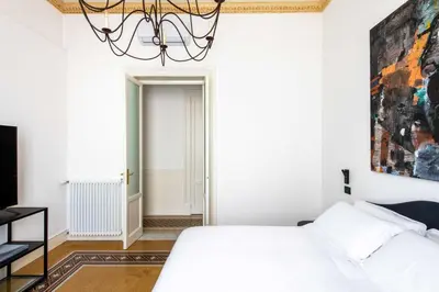 a bedroom with a white bed and a chandelier at Libertà 78 - Art Suite & Spa in Palermo
