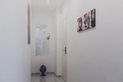 a white hallway with a blue vase next to a door at Mariblu Palermo in Palermo