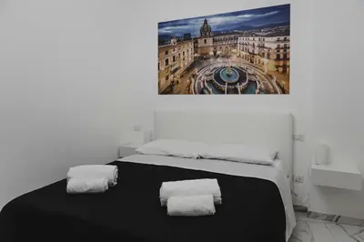 a room with a bed with a picture on the wall at Mariblu Palermo in Palermo