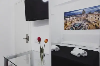a room with a bed with a vase of flowers at Mariblu Palermo in Palermo