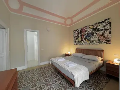 a bedroom with a bed and a painting on the wall at La casa di Alice Palermo Casa Professa in Palermo