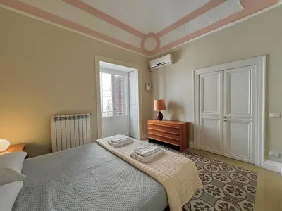 a bedroom with a bed and a dresser and a window at La casa di Alice Palermo Casa Professa in Palermo