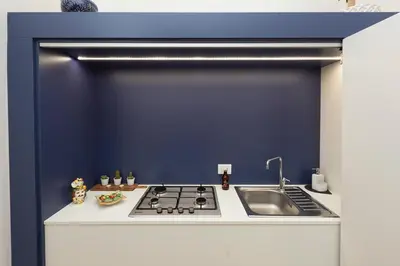a kitchen with a sink and a blue wall at Massim'home in Palermo