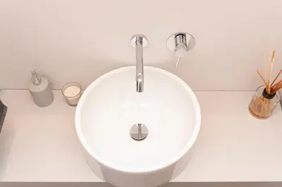 a white sink in a white bathroom with sticks at Massim'home in Palermo