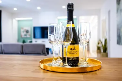 a bottle of champagne and four wine glasses on a tray at Oasi Libertà in Palermo