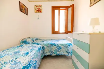 a bedroom with two twin beds and a dresser at Calasole House: Mare a 2 Passi in San Vito lo Capo