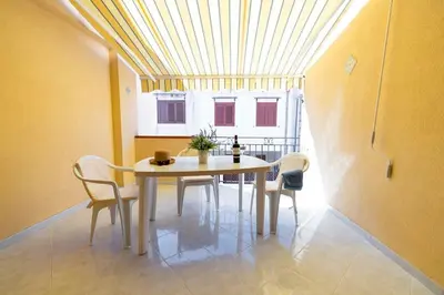 a dining room with a table and chairs and a window at Calasole House: Mare a 2 Passi in San Vito lo Capo