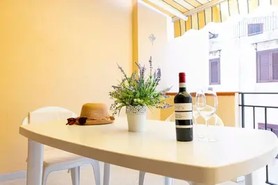 a white table with a bottle of wine on it at Calasole House: Mare a 2 Passi in San Vito lo Capo
