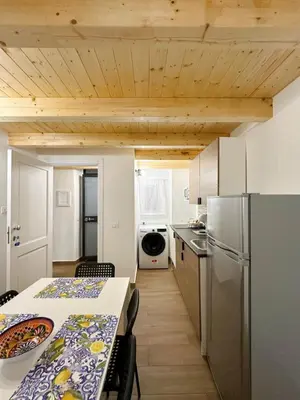 a kitchen with a table and a refrigerator at M&F Home in Palermo