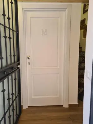 a white door with the letter m on it at M&F Home in Palermo