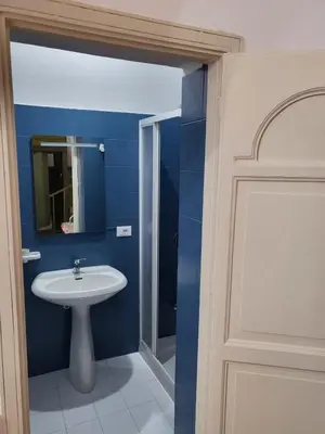 a blue bathroom with a sink and a mirror at Casa Vacanze Sole in Castellammare del Golfo