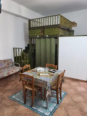 a dining room with a table and chairs and a bed at Casa Vacanze Sole in Castellammare del Golfo