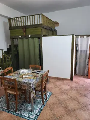a dining room with a table and chairs and a whiteboard at Casa Vacanze Sole in Castellammare del Golfo