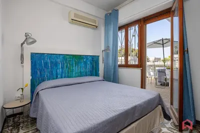 a bedroom with a bed with a blue head board at Matasca casa vancanze in Palermo