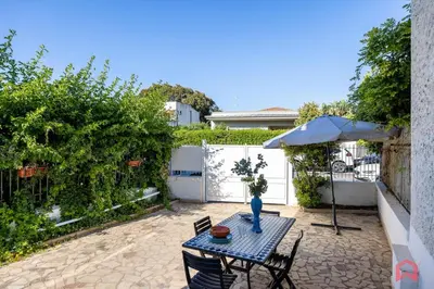 a patio with a table and chairs and an umbrella at Matasca casa vancanze in Palermo