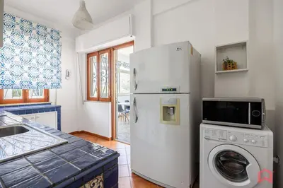 a kitchen with a refrigerator and a washing machine at Matasca casa vancanze in Palermo