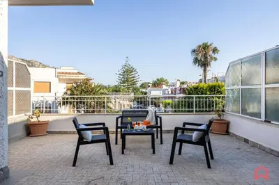a patio with chairs and a table on a balcony at Matasca casa vancanze in Palermo