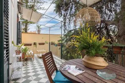 a patio with a wooden table and a potted plant at Buffa Apartaments by DomuSicily in Mondello