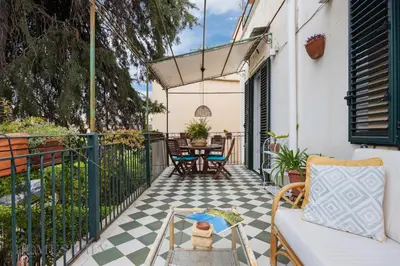 a patio with a table and chairs on a balcony at Buffa Apartaments by DomuSicily in Mondello