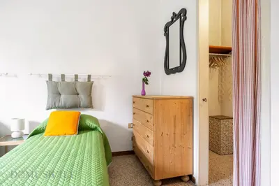 a bedroom with a bed and a wooden dresser at Buffa Apartaments by DomuSicily in Mondello