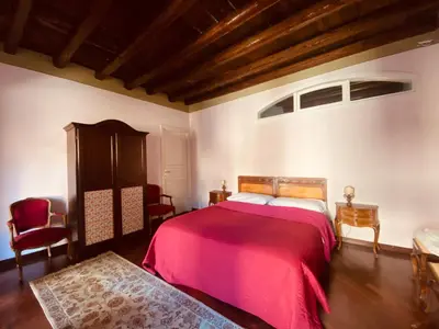 a bedroom with a large bed with a red blanket at casetta mon amour in Palermo