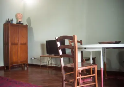 a room with a table and a chair and a desk at casetta mon amour in Palermo