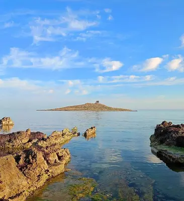 a small island in the water with a lighthouse on it at Casa giambona in Capaci