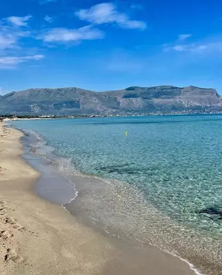 a beach with mountains in the background and the ocean at Casa giambona in Capaci