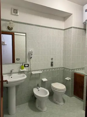 a bathroom with a sink and a toilet and a mirror at A Casa di Amy 2.0 in Macari