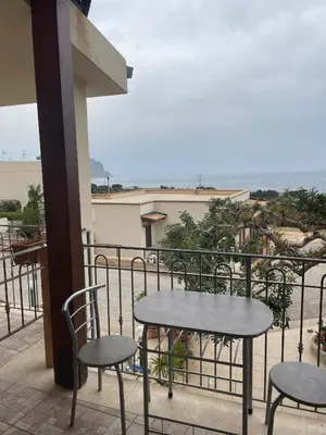 a table and chairs on a balcony with a view of the ocean at A Casa di Amy 2.0 in Macari