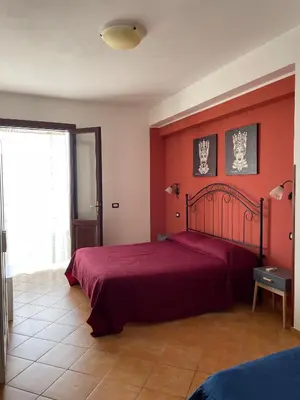 a bedroom with a bed with a red wall at A Casa di Amy 2.0 in Macari
